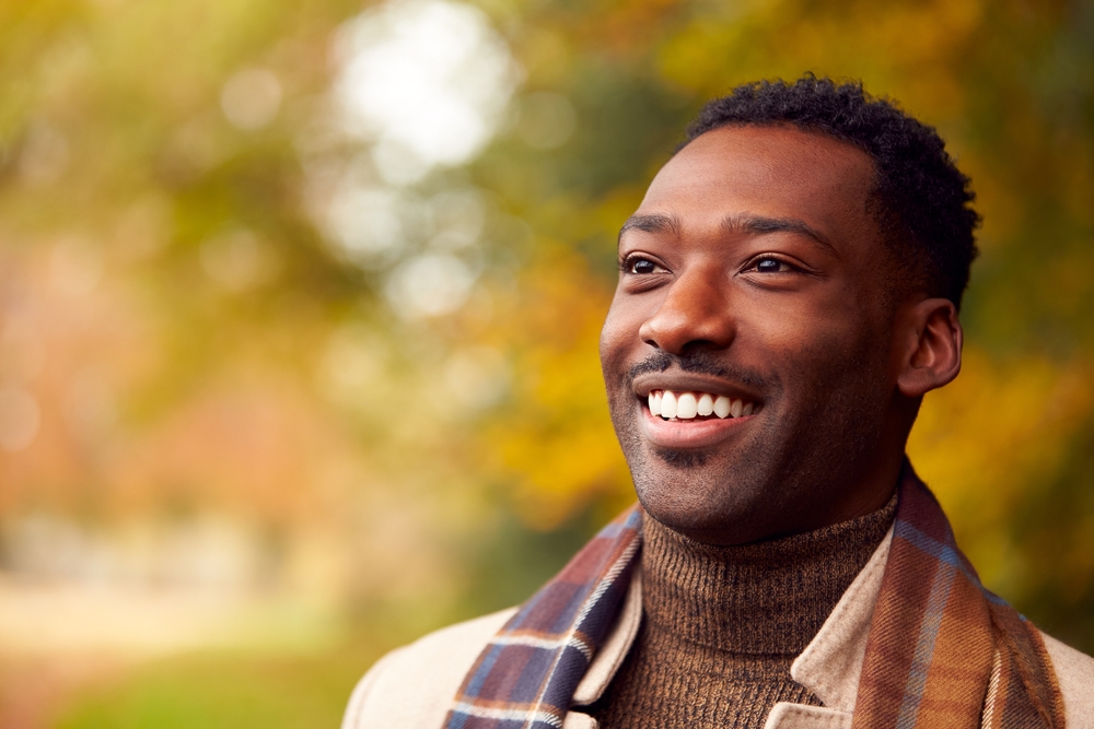 Confident Smiling Patient Portrait – Tesoro Dental A happy male patient smiling confidently outdoors, representing healthy teeth and beautiful smile results from professional dental care - Tesoro Dental